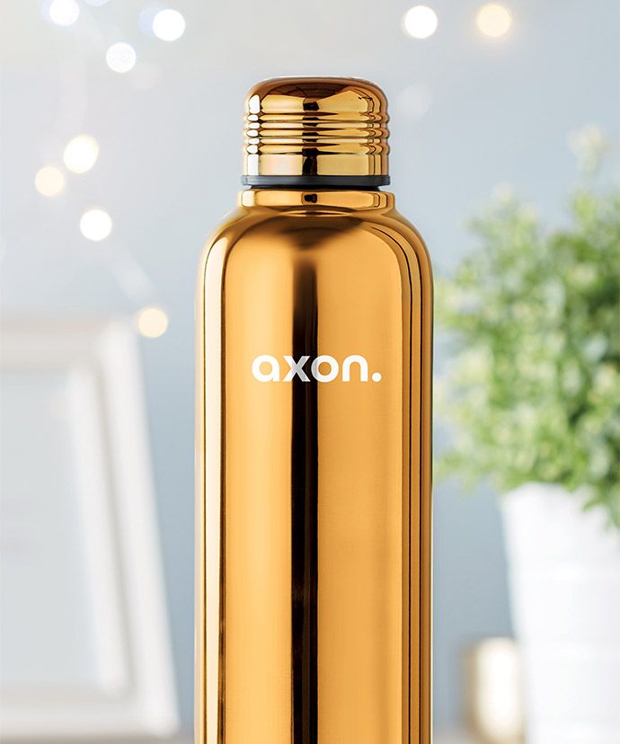 Guldfärgad termos med tryck med växt i bakgrunden. Profilprodukt för vintern.