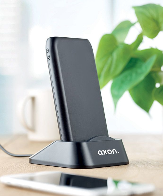 Svart trådlös laddare med tryck på ett bord. Profilprodukter för kontoret.